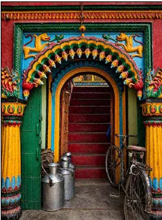 Painting of a brightly coloured Banarasi doorway with milk pails and a bicycle parked outside